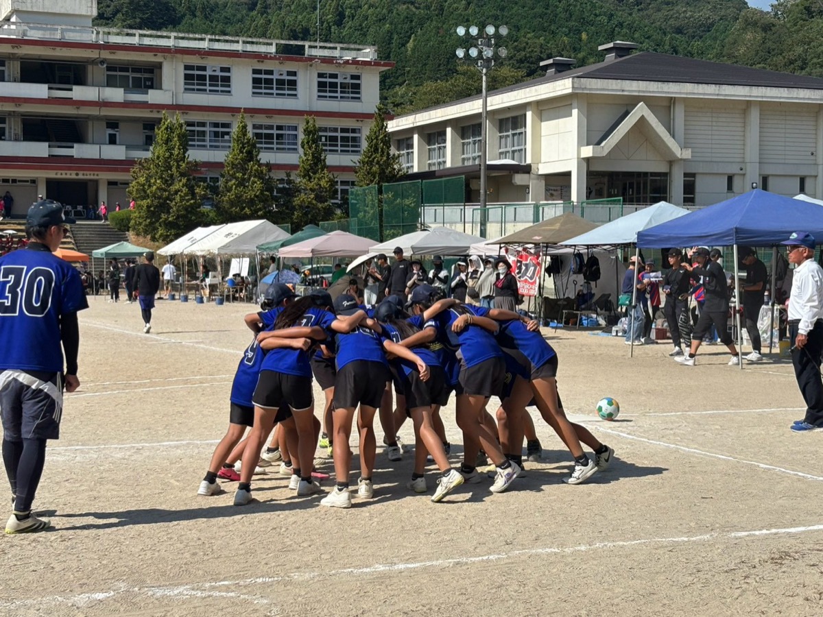 グラウンドで円陣を組む古江の子ども会フットベースチームの写真